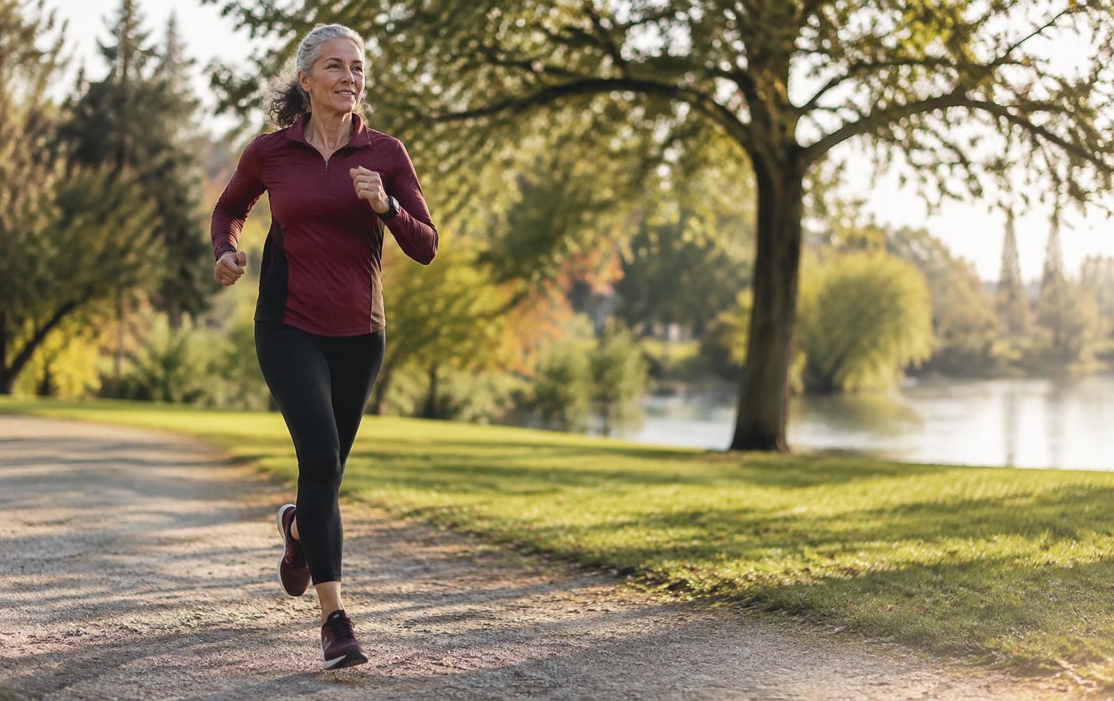 Older adult runner moving steadily along a sunlit park path.